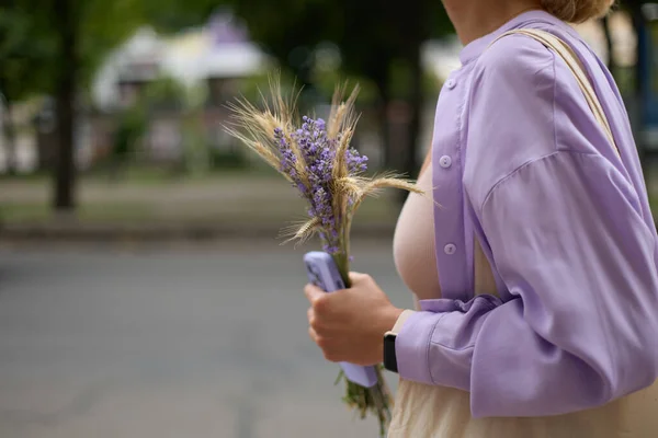 Onherkenbare Vrouwelijke Persoon Loopt Met Een Lavendel Bloemboeket Moderne Smartphone — Stockfoto