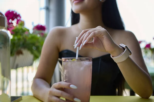テラスで冷たい夏のカクテルを飲む若い女の子 冷たい飲み物を手にしたレストランに座っている認識できない若いアジアの女性 — ストック写真