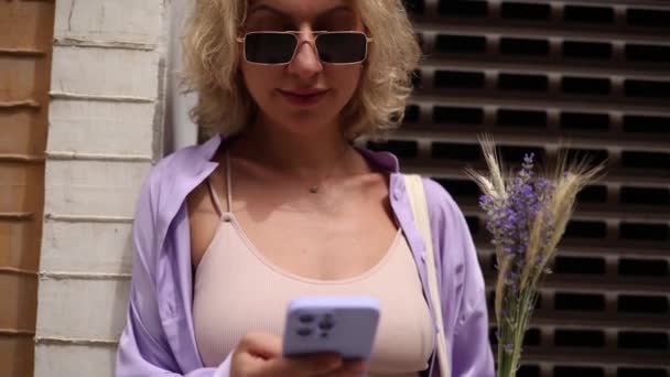 야외에 스마트폰에서 모바일 둘러보고 선글라스를 여성의 — 비디오