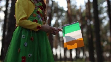 Little girl dressed as a fairy waving with Irish flags in close up video clip