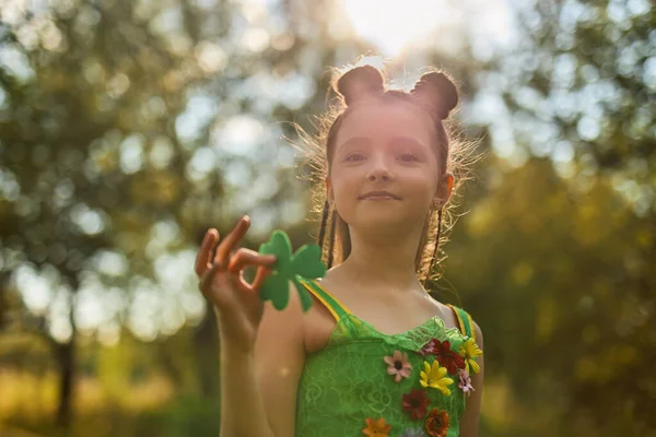 在圣帕特里克节庆祝活动上展示装饰三叶草叶子的可爱女孩 — 图库照片