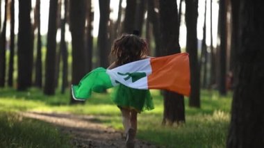 Aziz Patrick Günü kutlaması. İrlanda bayrağıyla ağır çekimde koşan sevimli küçük kız.