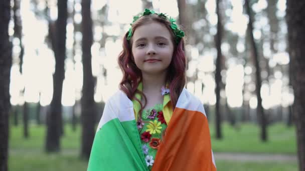 美しい赤い頭の少女は妖精として服を着て セントパトリックの日にアイルランドの旗で覆われた — ストック動画