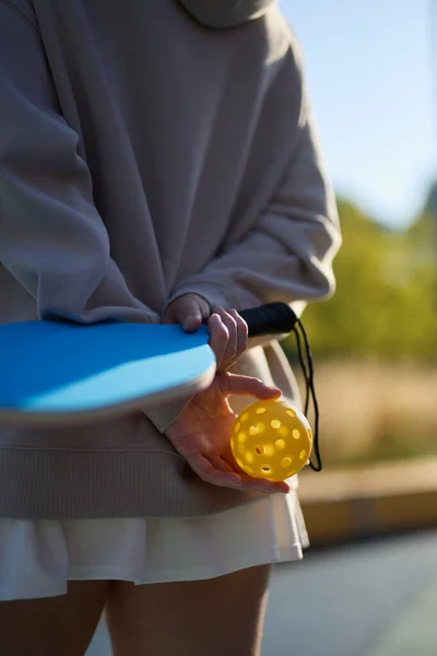 stock image Pickleball player holding a ball and a racket in hands