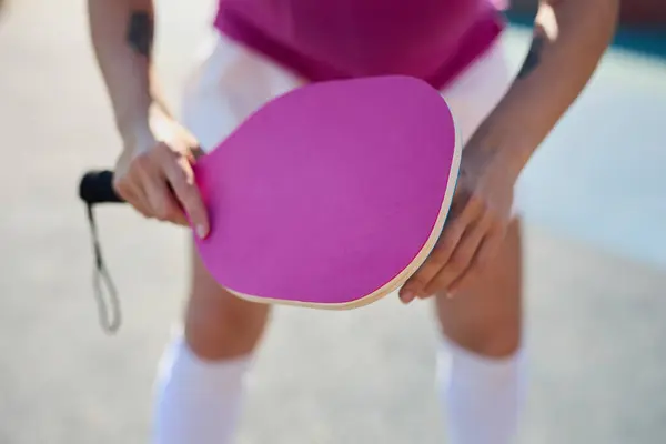 Pickle ball player holding a racket in hand