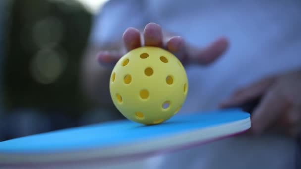 ピックルボールのためのラケットにボールを転がすピックラー — ストック動画