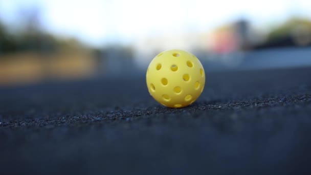 スローモーションで地面に回転ピックルボールのためのプラスチックボール — ストック動画