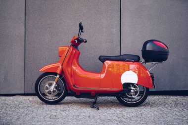 Kırmızı retro scooter. Şehir caddesinde eski bir motosiklet.