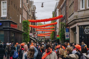 Amsterdam 'ın dekore edilmiş caddesi Krallar Günü' nde insanlarla doluydu. AMSTERDAM, NETHERLANDS-28 Nisan, 2019