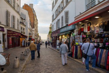 Günbatımında Montmartre 'de hediyelik eşya dükkanlarında ve galerilerde dolaşan bir turist. PARIS - 29 Nisan, 2019