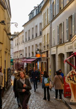 İnsanlar gün batımında Montmartre 'nin dar sokaklarında yürüyorlar. PARIS - 29 Nisan, 2019