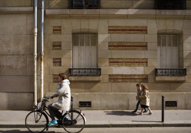 Sokaktaki Parisliler. Yürüyen küçük Fransız çocuklar ve şehrin ortasında bisiklet süren bir kadın. PARIS - 29 Nisan, 2019