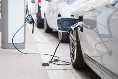 Şehir caddesinde elektrikli araba şarj oluyor. Modern CO2 nötr araç şarj edildi