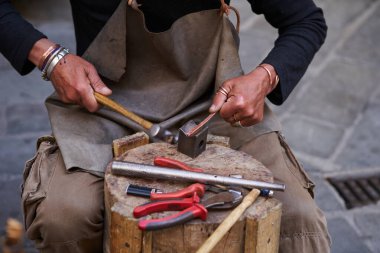 Eski Ceneviz Limanı 'nda turistler için bakır aksesuar yapan bir zanaatkar. GENOVA - 1 Mayıs 2019