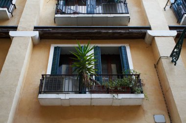 Venezia 'nın yerleşim bölgesinde pencere eşiğinde panjurları ve bitkileri olan bir pencere. Venedik - 4 Mayıs 2019
