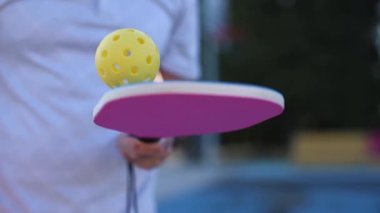 Pickleball oyuncusu ağır çekimde topla hokkabazlık yapıyor.