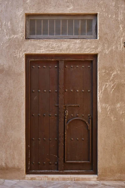 Old wooden door on the arabic residential building in Al Fahidi, historic district of Dubai