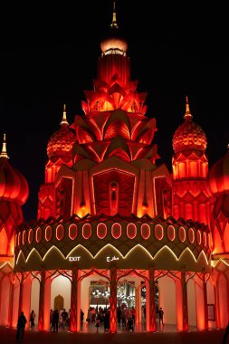 Küresel Köy eğlence parkındaki parlak kırmızı ışıklarla aydınlatılmış kule. Dubai, BAE - 5 Şubat 2020