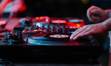 DJ bir konser sahnesinde müziği karıştırıyor. Disk şakası, gece kulübündeki bir döner masa oyuncusunun plağını çizer.