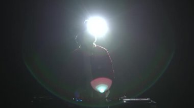 Noel Baba 'nın silueti bir gece kulübünde müzik çalıyor. Geleneksel kırmızı Noel kıyafetli disk jokeyi