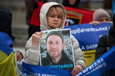 Ukraynalı kadın, Ukrayna Silahlı Kuvvetleri 'nin kayıp kocasının bir portresini taşıyor. Kyiv - 25 Şubat 2024