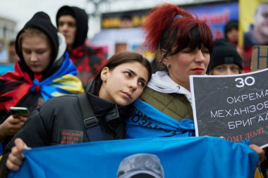 30. Tugay 'ın kayıp Ukraynalı askerinin kızı ve karısı halk mitinginde portresini tutuyordu. Kyiv - 25 Şubat 2024