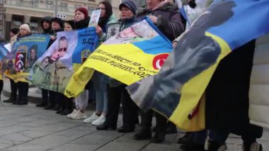 Kayıp Ukraynalı askerlerin aileleri, 25 Şubat 2024 'te Kyiv' de düzenlenen bir gösteride bayraklar ve portrelerle ayakta duruyorlar.