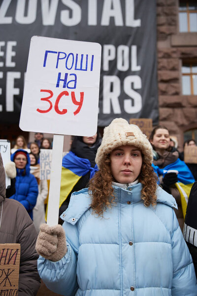 Ukrainian woman holds a banner "Money On Army" on a public demonstration for increase of military budget at the city council (KMDA) building. Kyiv - 17 February,2024