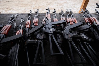 Askeri poligon masasında düzinelerce AK tüfeği var. Ukrayna 'daki deneme sahasında taktik eğitimi için hava yumuşak silahları. Kyiv - 27 Ocak 2024