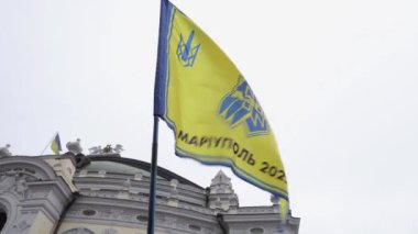 Üzerinde Azov tugayı logosu olan Ukrayna bayrağı ve açık havada 