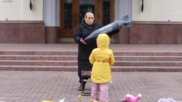 Actor Con Una Máscara Putin Amenazando Niño Ucraniano Con Cohete — Vídeo de stock