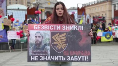 Kayıp kocasının portresiyle poz veren üzgün Ukraynalı kadın, Ukrayna Silahlı Kuvvetleri 'nin 95. tugayının askeri. Kyiv - 16 Mart 2024