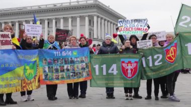 Ukrayna 'nın 114. Bölgesel Savunma Tugayı' nın aileleri yakalanan akrabalarının afişleri ve portreleriyle poz veriyorlar. Kyiv - 16 Mart 2024