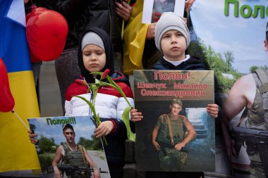 Üzgün Ukraynalı çocuklar, Rus esaretinde kalan babalarının portreleriyle poz veriyorlar. Kyiv - 16 Mart 2024