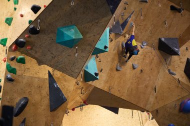 Tırmanan sporcu çokgen tırmanma duvarına tırmanıyor. Kyiv - 10 Mart 2024