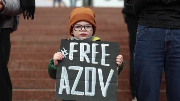 一名乌克兰小男孩举着 自由阿佐夫 的旗帜 为释放在Mariupol市被俘的维权者举行公众示威 2024年3月24日 — 图库视频影像