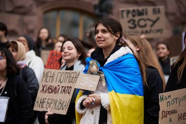 23 Mart 2024 'te Kyiv' de düzenlenen halk gösterisinde omuzlarında Ukrayna bayrağı taşıyan neşeli genç kız.