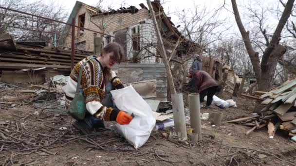 ロシアの弾道ミサイルによって破壊された古い家の残骸でゴミを分類するウクライナのボランティア キエフ 2024 — ストック動画