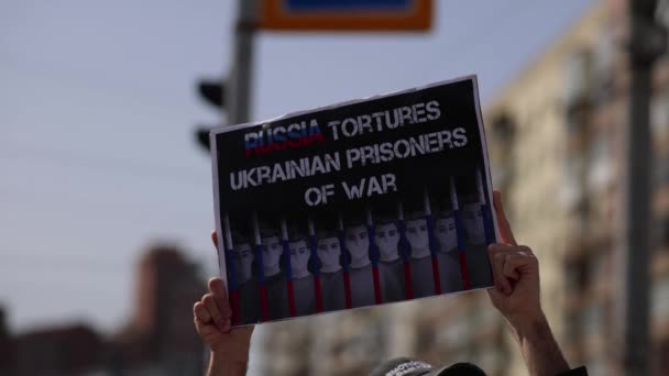 Человек Показывает Баннер Россия Пытает Украинских Военнопленных Публичной Демонстрации Освобождение — стоковое видео