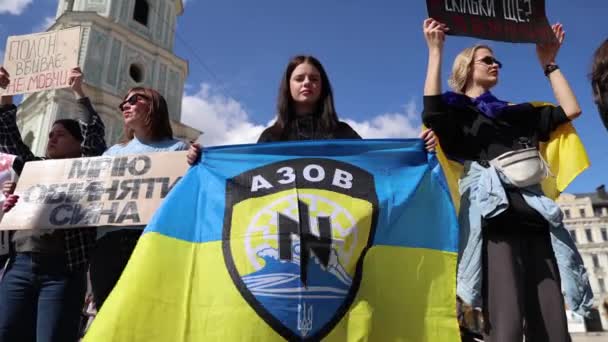 若いウクライナの少女は マリポルとアゾフスタル工場の囚人守備に捧げられたデモンストレーションでアゾフ旅団の旗を掲げた キエフ 2024 動画クリップ