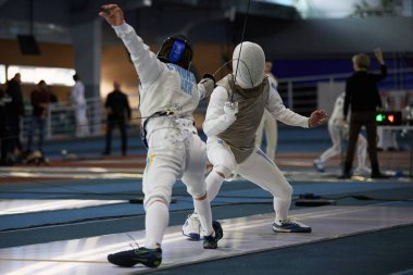 Koruyucu topal ceketler ve maskeler giyen eskrimciler Ukrayna Ulusal Eskrim Şampiyonası sırasında kavga ediyorlar. Kyiv - 30 Mart 2024