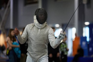 Ukrayna Ulusal Eskrim Şampiyonası 'nda koruyucu maske takan profesyonel bir eskrimcinin portresi. Kyiv - 30 Mart 2024
