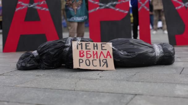 在一个公共集会上 一个标有 俄国人杀了我 标志的尸袋在 Mariupol 的横幅下展示 2024年4月13日 图库视频