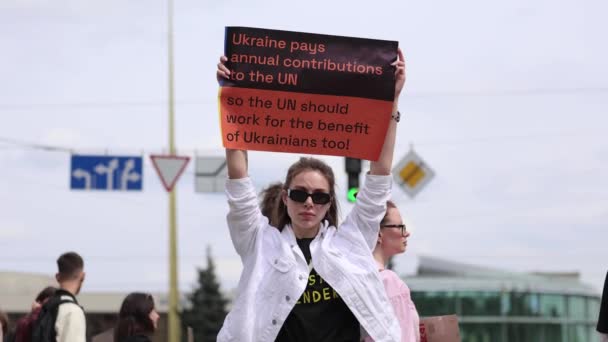 ウクライナの若い女性が ウクライナは国連に貢献する というサインを掲げた だから 国連は働くべきか ウクライナ人の利益も必要だ 公のデモンストレーションで キエフ 2024 ロイヤリティフリーのストック動画