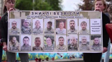 Ukraynalı kadınların elinde Ukrayna Silahlı Kuvvetleri 'nin kayıp askerlerinin portrelerinin olduğu bir pankart var. Kyiv - 14 Nisan 2024