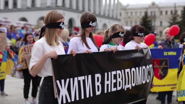 乌克兰的演出 在专门为失踪人员举行的集会上 眼睛被绑住的妇女举着 生活在未知之中 的横幅 2024年4月14日 — 图库视频影像