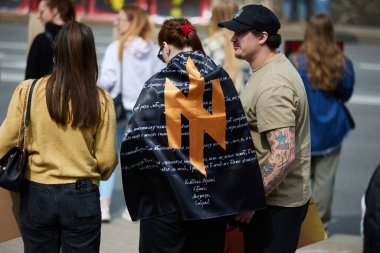 Ukraynalı aktivist Ukraynalı bir milliyetçinin dualarıyla Azov tugayının bayrağını halka açık bir gösteride takıyor. Kyiv - 14 Nisan 2024