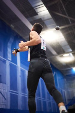 Heptathlon Vuruşu 7,260 kilo erkek finali koydu. Atlet Artem Shcherbyna Ukrayna Koşu ve Saha Şampiyonluğu için bir atış yapıyor. Kyiv - 3 Şubat 2024