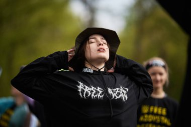 20 Nisan 2024 'te Kyiv' deki Sparta Yarışı 'nda antrenman öncesi streç egzersizleri yapan genç bir kadın.