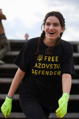 Neşeli Ukraynalı kadın, 20 Nisan 2024 'te Kyiv' deki Sparta Yarışı 'nda kayma duvarı yarışmasına katılıyor.